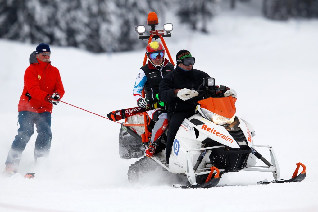 Marcel Hirscher's father, Ferdinand, hitches a ride off the back of a snow machine during training in Reiteralm. GEPA
