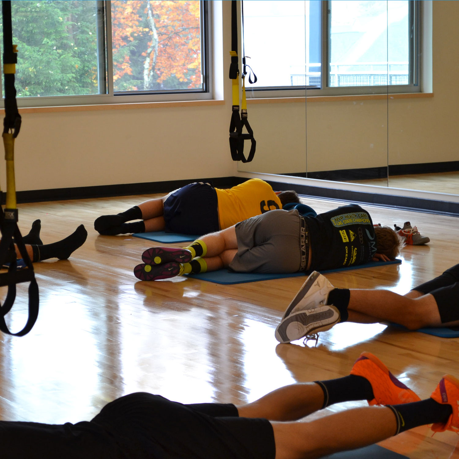 Athletes stretch out in the yoga studio space outfitted with TRX equipment.